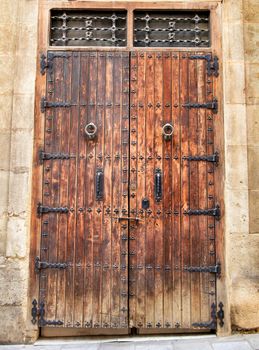 Old and colorful wooden door with iron details in Alicante, Spain
