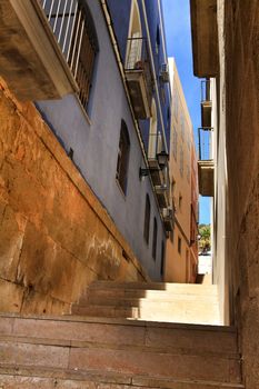 Narrow streets with old facades, windows and balconies of Santa Cruz  neighborghood in Alicante city