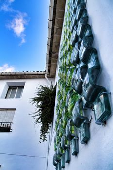 Narrow streets and beautiful white facade with green glass details in Carricola, Valencia, Spain