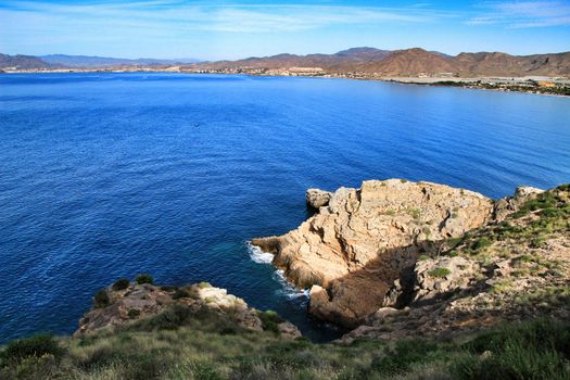 Beautiful beach with boats , cliffs and mountains in La Azohia village in Cartagena, Murcia, Spain in a sunny day. Views from Santa Elena tower viewpoint.