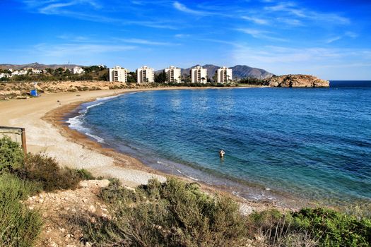 Beautiful Mojon beach in Isla Plana, Cartagena, Murcia, Spain. Buildings in the background.