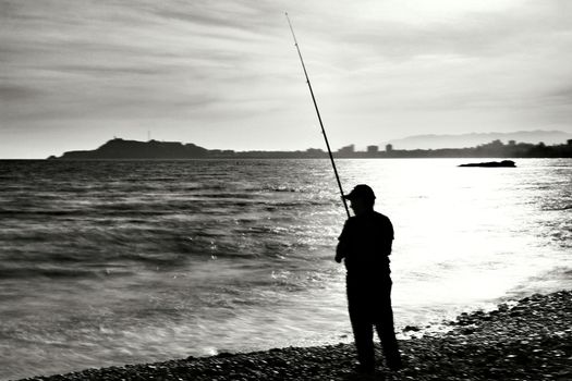 Fisherman in the evening on Mojon beach in Isla Plana, Cartagena, Murcia,Spain.
