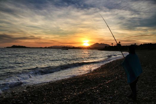 Fisherman at Sunset on Mojon beach in Isla Plana, Cartagena, Murcia,Spain.
