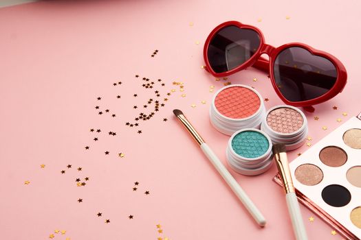 eyeshadow accessories beads makeup brushes collection professional cosmetics on pink background. High quality photo