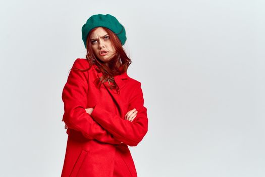 Woman in red coat and in green hat on isolated background cropped model with Copy Space emotions. High quality photo