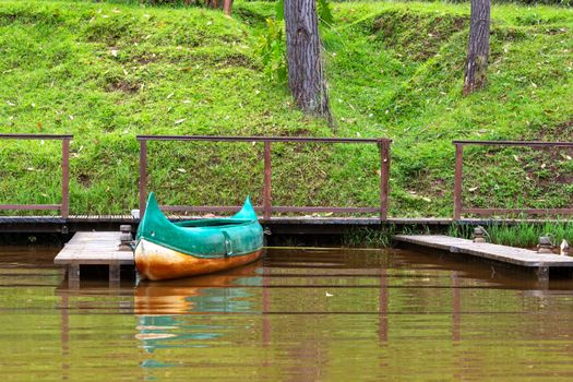 One boat on a lake is parked on a jetty