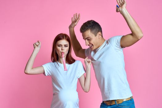 pregnant mom and happy father on pink background Young family waiting for baby. High quality photo