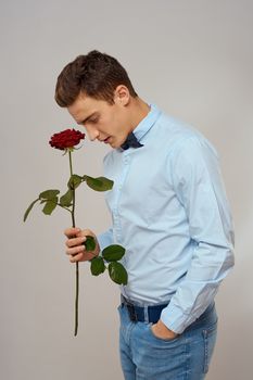 romantic man with red rose and light shirt pants suit. High quality photo