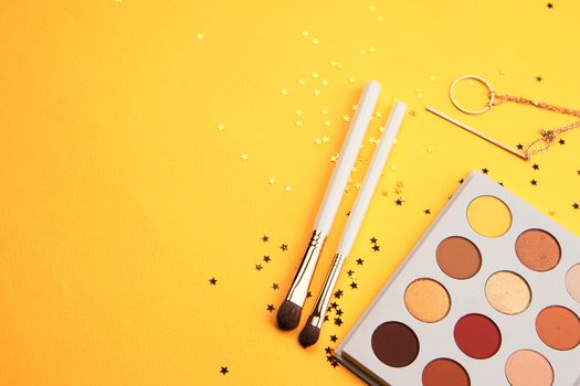 Professional eyeshadows and makeup brushes on a yellow background make-up decoration. High quality photo