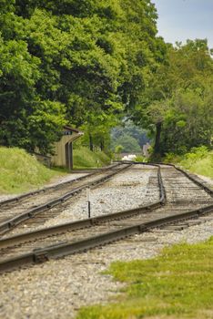 Two Rail Road Tracks on a Lonely small Rail Road Station on a Sunny Day