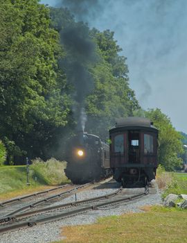 Restored Antique Steam Locomotive with Passenger Cars Steaming Up
