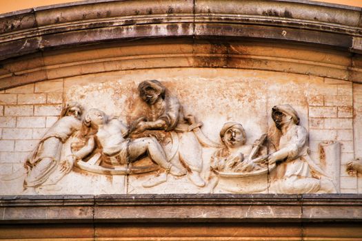 Scene carved in stone on facade of old and majestic house in Cordoba , Spain