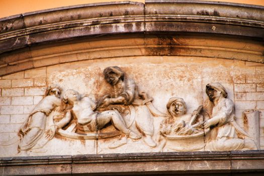 Scene carved in stone on facade of old and majestic house in Cordoba , Spain
