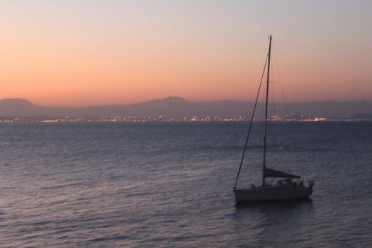 Sailboat anchored in the island of Tabarca, Alicante, at dusk in summer