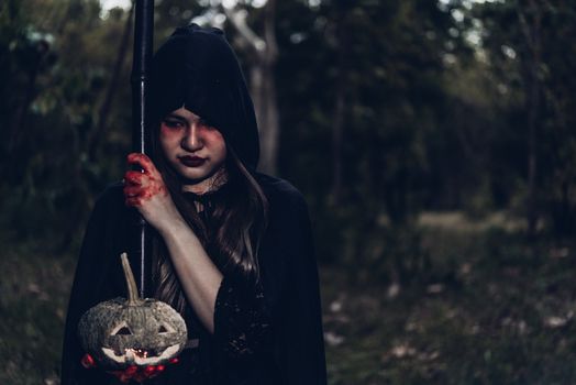 Woman ghost horror her have scythe on hand in forest, halloween day concept