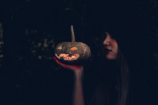 Portrait of woman ghost horror her have pumpkin on hand in forest, halloween day concept