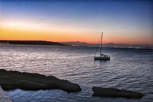 Sailboat anchored in the island of Tabarca, Alicante, at dusk in summer