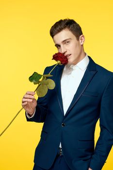 Gentlemen in classic suit on yellow background and red rose romance cropped view model portrait. High quality photo