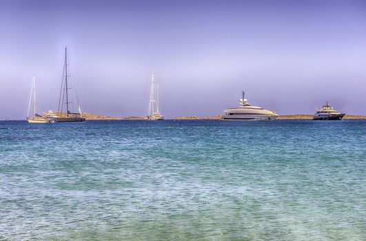 Luxury yachts standing in front of Liscia Ruja, one of the most beautiful beaches in Costa Smeralda, Sardinia, Italy