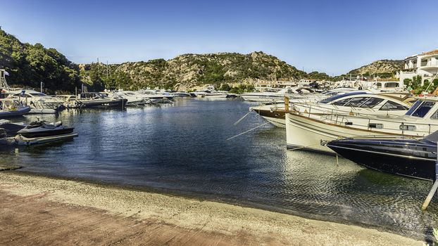 View of the harbor with luxury yachts of Poltu Quatu, Sardinia, Italy. This picturesque town is a real gem in Costa Smeralda and a luxury yacht magnet and billionaires' playground