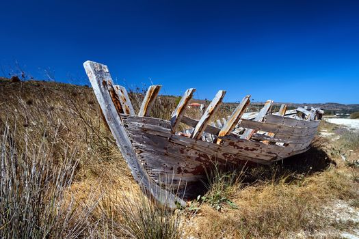 Skeleton of an old, damaged wooden boat on the seashore on the island of Kefalonia in Greece