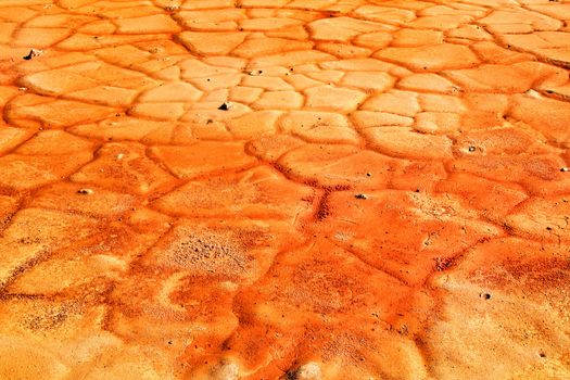 Colorful orange sediments deposited in a dry lake of an old abandoned mine in Mazarron, Spain