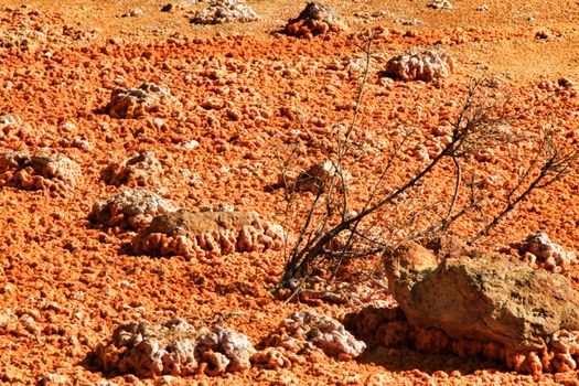 Colorful orange sediments deposited in a dry lake of an old abandoned mine in Mazarron, Spain