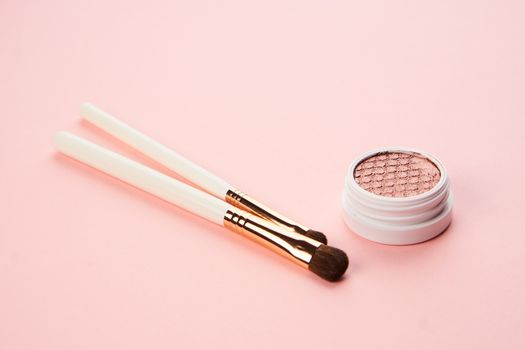 makeup brushes and eyeshadow professional cosmetics on pink background. High quality photo