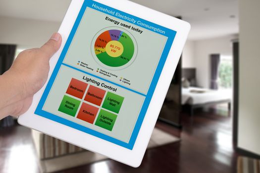 Household electricity consumption control system show on digital tablet in someone hand.