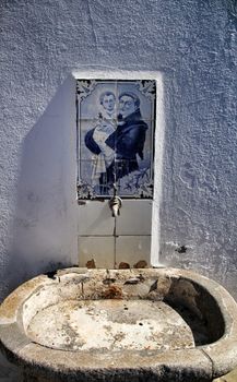 Old stone fountain with blessed water by saint in Azenhas do Mar in Lisbon, Portugal