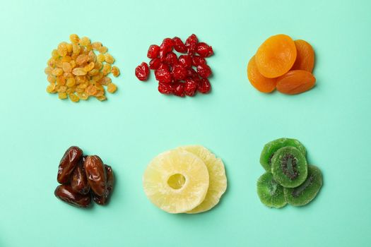 Tasty dried fruits on mint background, top view