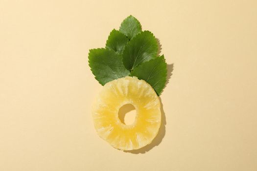 Dried pineapple and leaves on beige background