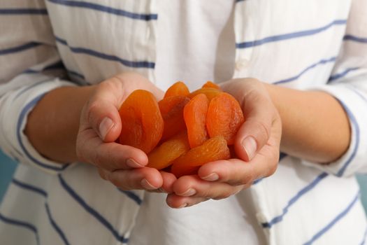 Woman hold tasty dried apricots, close up