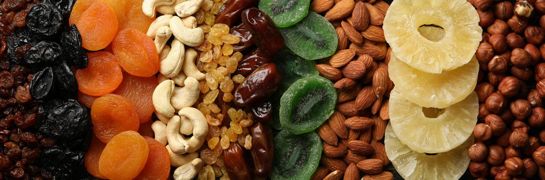 Dried fruits and nuts on wooden background, top view