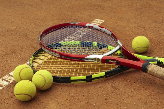 Tennis racquets with tennis balls on clay court