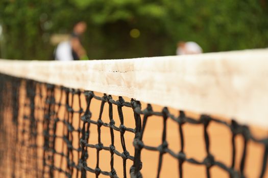 Clay tennis court with net, close up