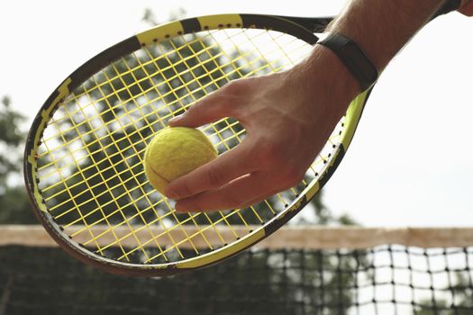 Man hold racket and tennis ball, close up