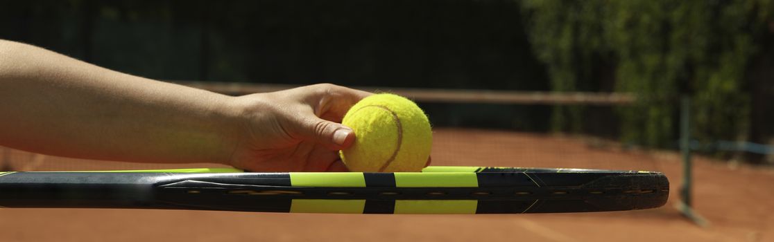 Woman hold racket and tennis ball on clay court