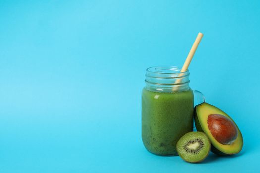 Smoothie, avocado and kiwi on blue background