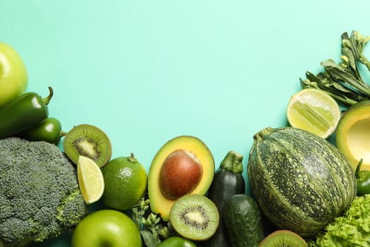 Green vegetables and fruits on mint background