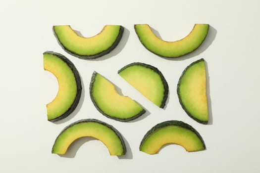 Fresh green avocado slices on white background