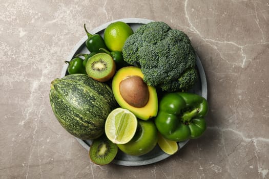 Tray with vegetables and fruits on gray table