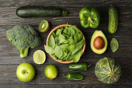 Green vegetables and fruits on wooden background