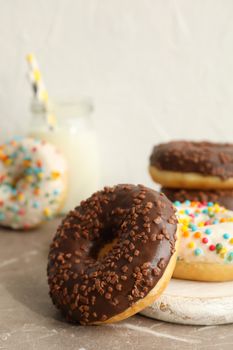Jar of milk and tasty donuts on gray table