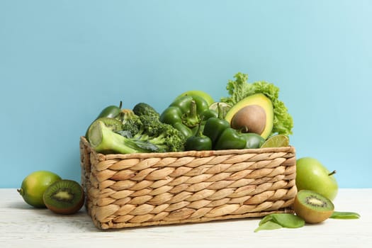 Basket with vegetable and fruits on blue background