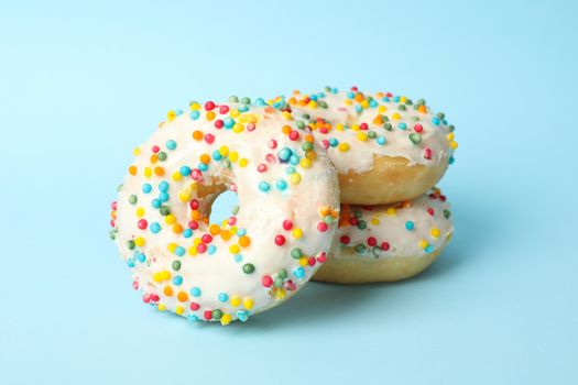 Tasty donuts on blue background, close up