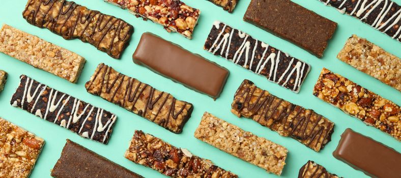 Flat lay with tasty granola bars on mint background, top view