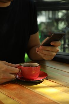 Man using phone and drink coffee in restaurant