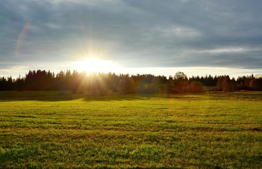 Beautiful sunset over meadow and forest near Kvilda village in Sumava National Park landscape.