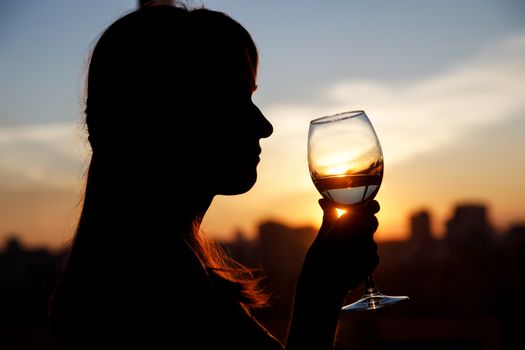 Girl with wine glass. Black silhouette